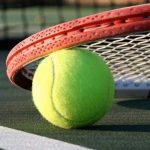 pallina da tennis gialla sotto racchetta arancione
